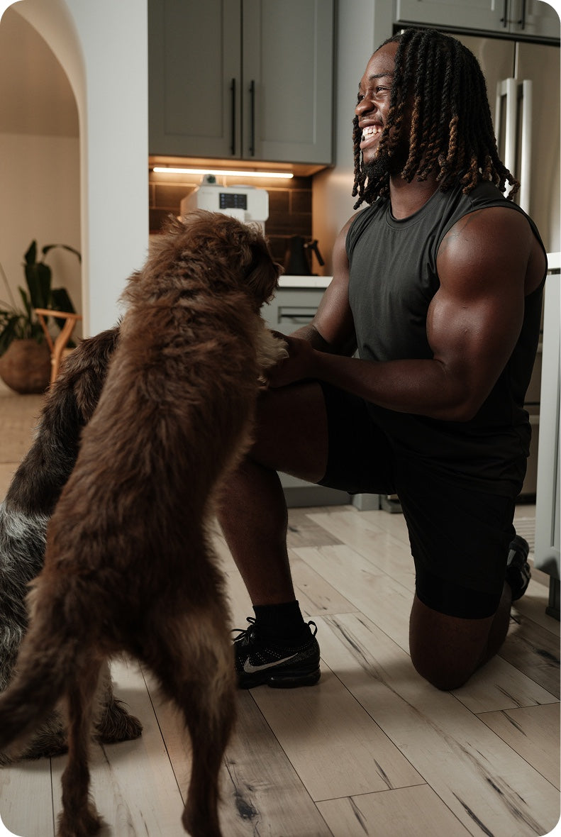 Ashton greeting his dogs in the kitchen